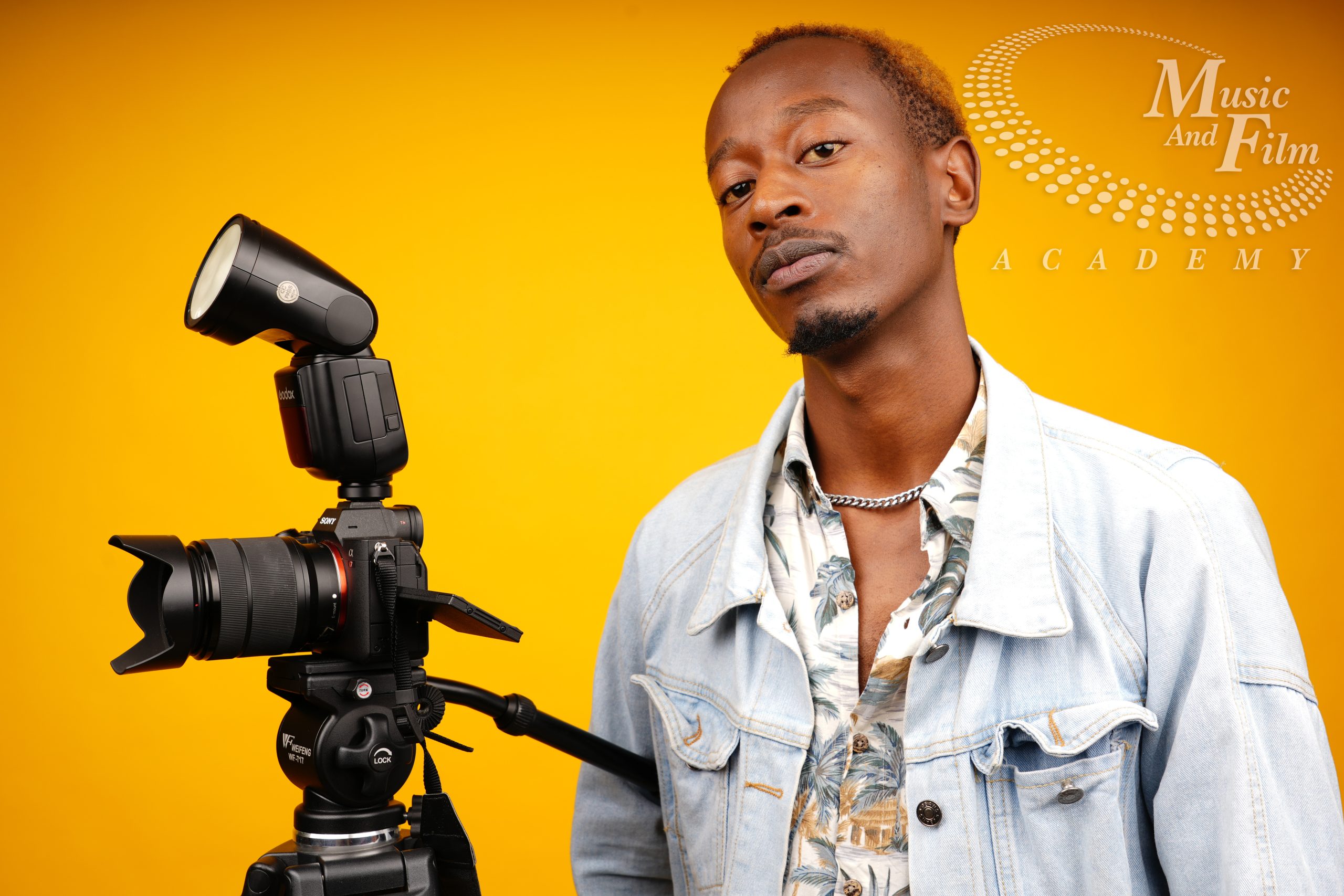 Photography student at Music and Film Academy learning manual camera settings and the exposure triangle in a professional studio.