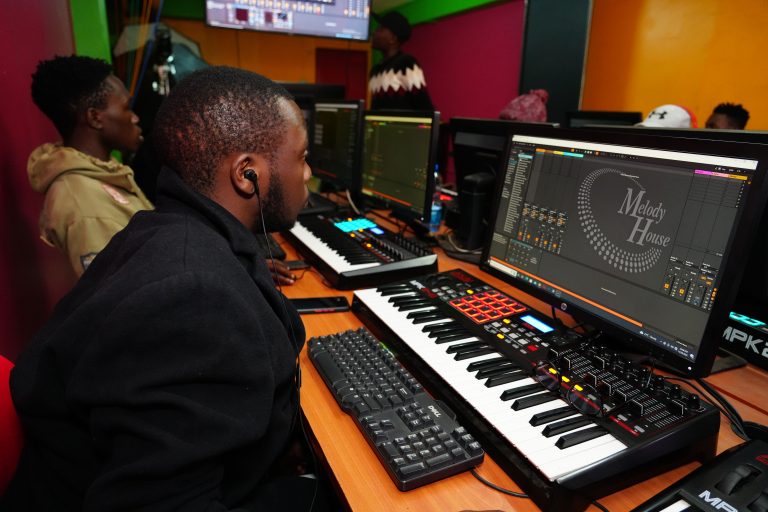 A student at Music And Film Academy in Nairobi Student learning how to start making beats in Nairobi at Music And Film Academy using Ableton Live and a MIDI keyboard controller in a professional studio setting.