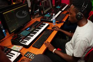 A production student at Music And Film Academy Nairobi using an Akai MPK249 MIDI controller to apply music theory hacks to a multi-track DAW session.
