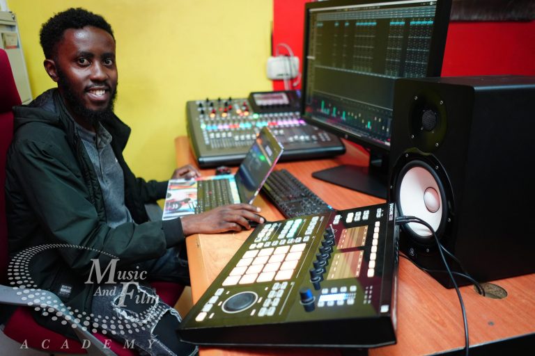 A professional recording studio setup comparing music production gear like a MIDI keyboard with sound engineering tools like a Behringer X32 digital mixing console at Music And Film Academy Nairobi.