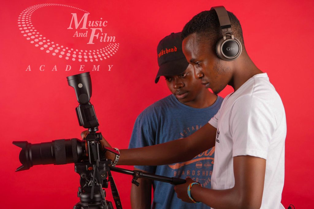 Two students operating a camera and lighting setup during practical training for photography and videography courses in Kenya at Music And Film Academy Nairobi.