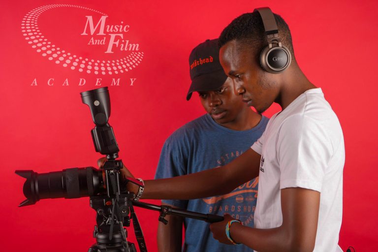 Two students operating a camera and lighting setup during practical training for photography and videography courses in Kenya at Music And Film Academy Nairobi.