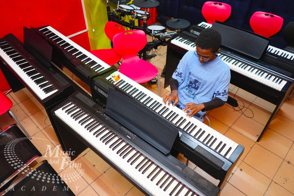 Student taking piano lessons on Yamaha digital keyboards at Music And Film Academy, ranked #1 best music school in Kenya